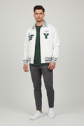 An off-white zip-up varsity jacket with green and gray striped ribbed collar, cuffs, and hem. The front features large collegiate-style letters 'IF' and 'Y' in dark green, with small graphic prints on the chest.