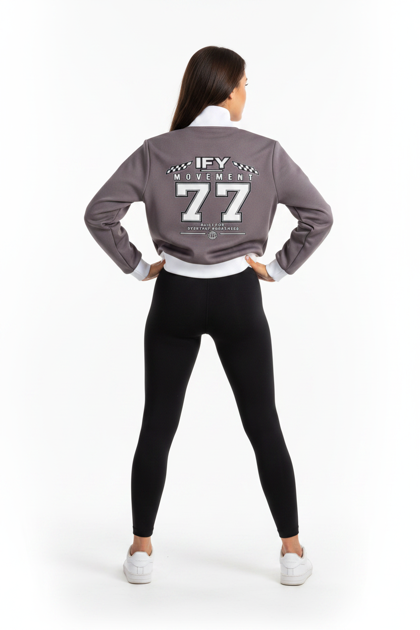 A dark gray cropped sweatshirt with white ribbed collar, cuffs, and hem, featuring a large white and gray graphic on the back that reads 'IFY MOVEMENT 77'.