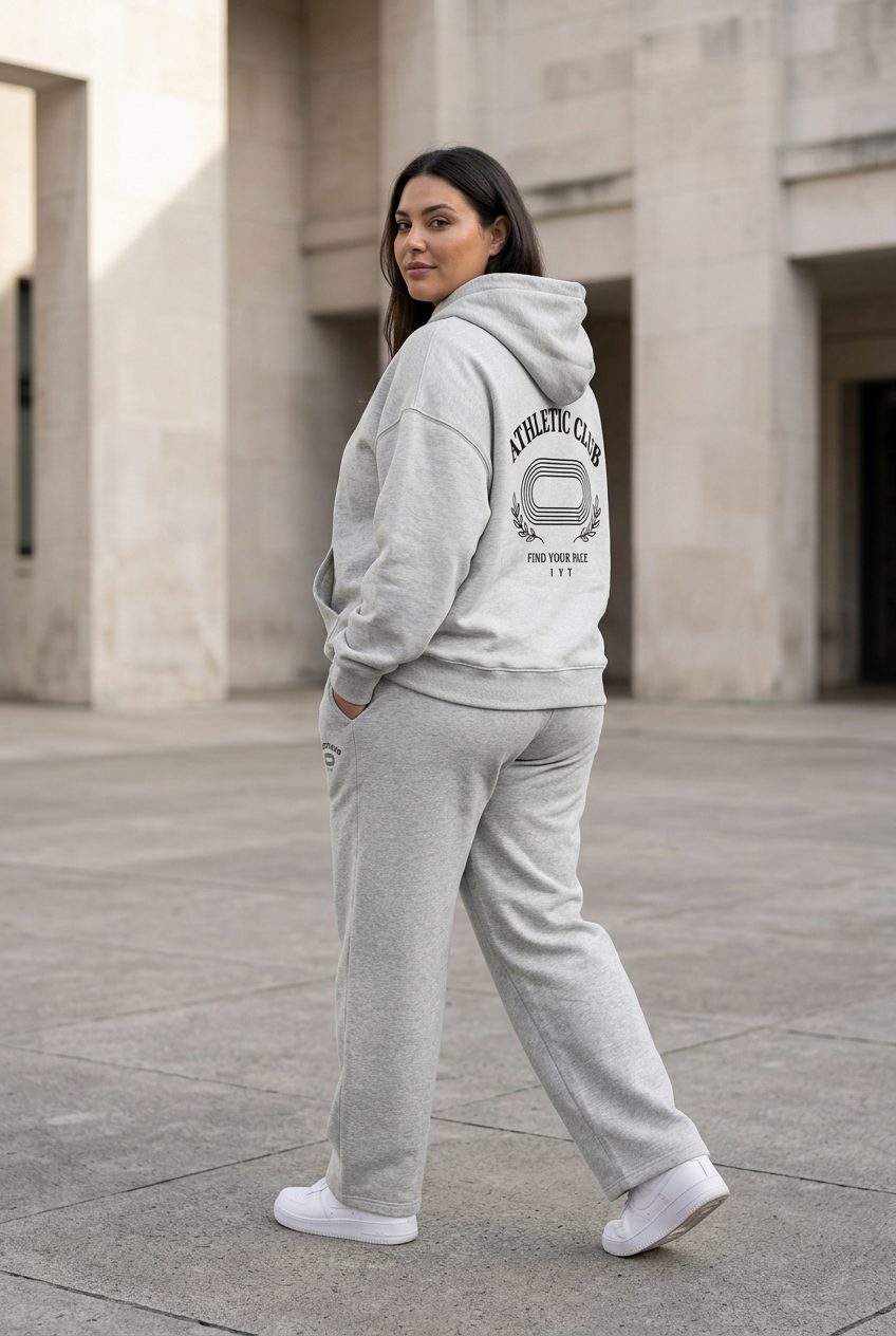 Female model in matching grey Athletic Club outfit showing the back design