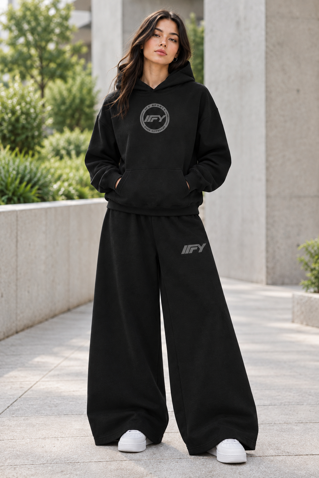 Female model wearing the black IFY set with wider-leg trousers
