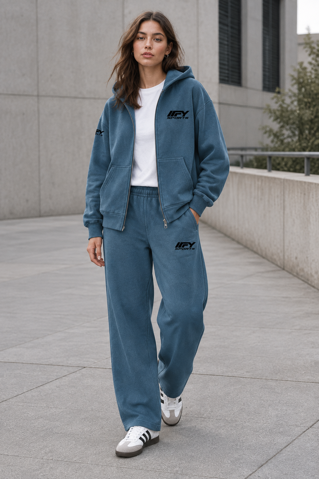 Female model wearing the blue IFY outfit with an open zip hoodie and Adidas trainers