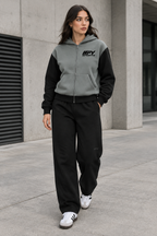 Female model wearing the grey-and-black IFY zip hoodie and black sweatpants with Adidas trainers