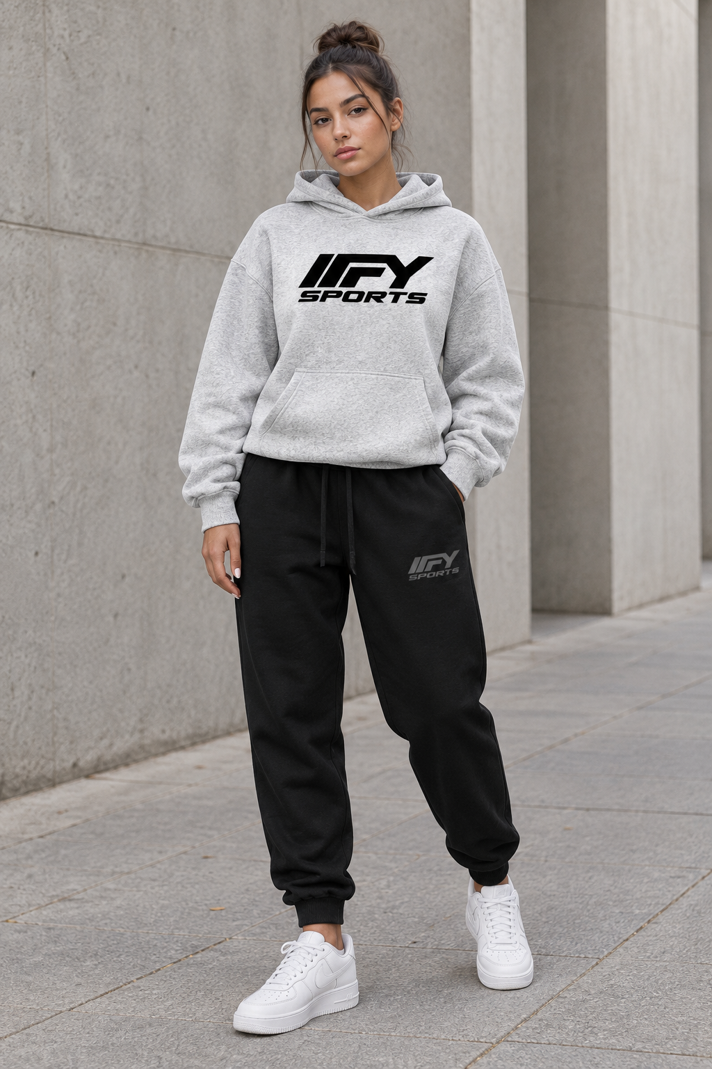 Female model wearing the grey IFY hoodie and black cuffed joggers with Nike trainers