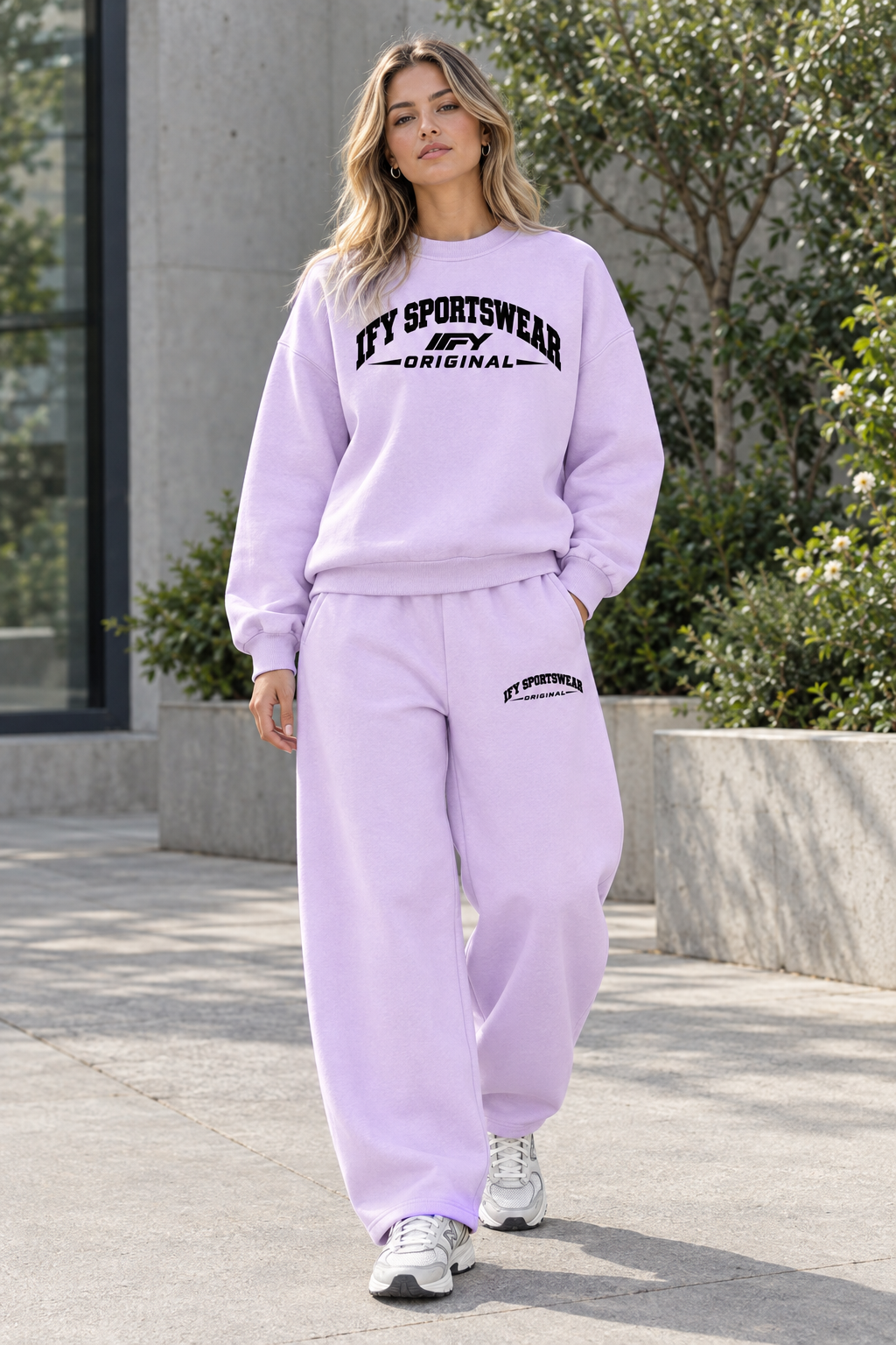 Female model wearing the lilac IFY SPORTSWEAR ORIGINAL sweatshirt and matching sweatpants outdoors