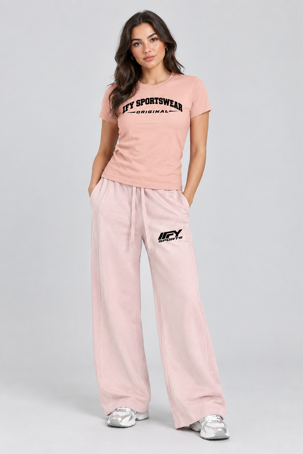 Female model wearing the pink IFY SPORTSWEAR ORIGINAL T-shirt and blush wide-leg IFY SPORTS trousers