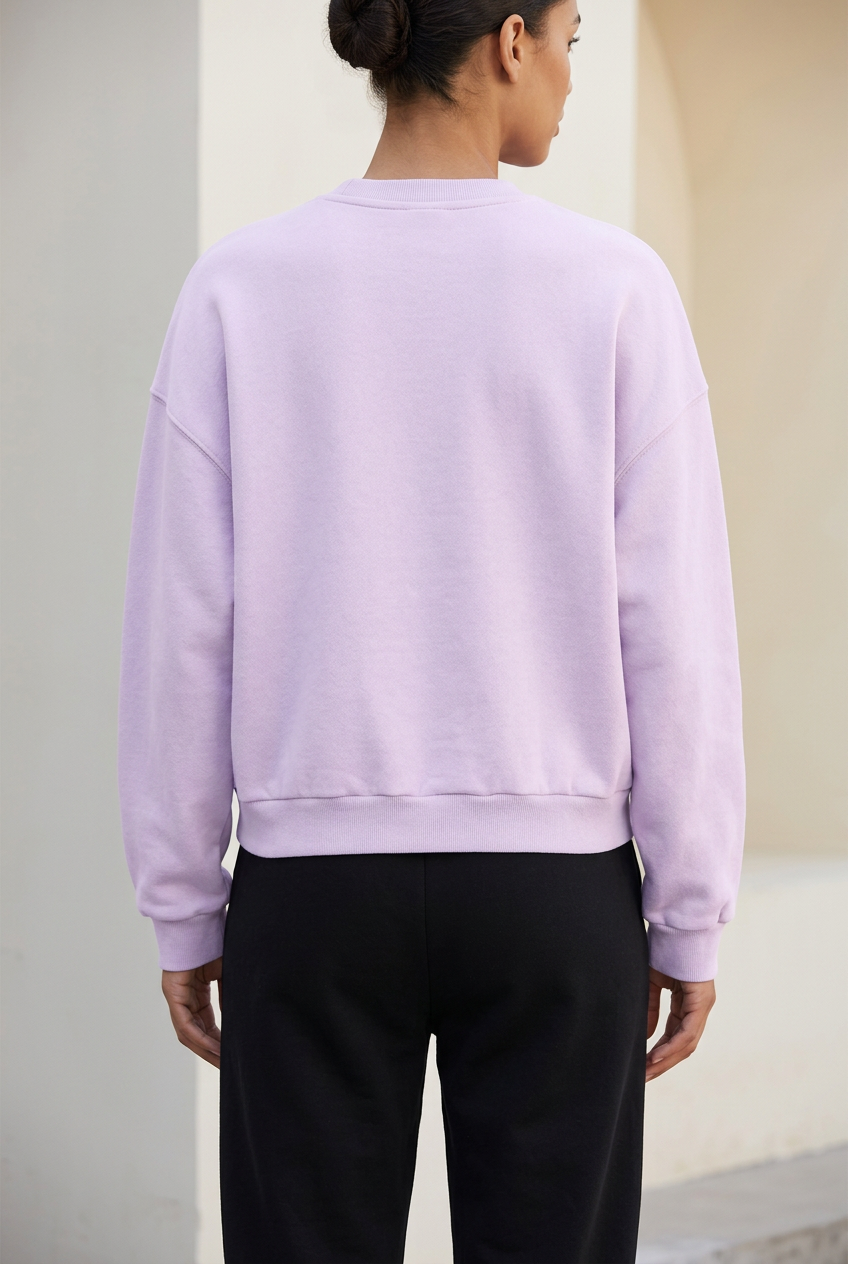 Plain back view of light-purple IFY boxy fleece sweatshirt worn by a female model