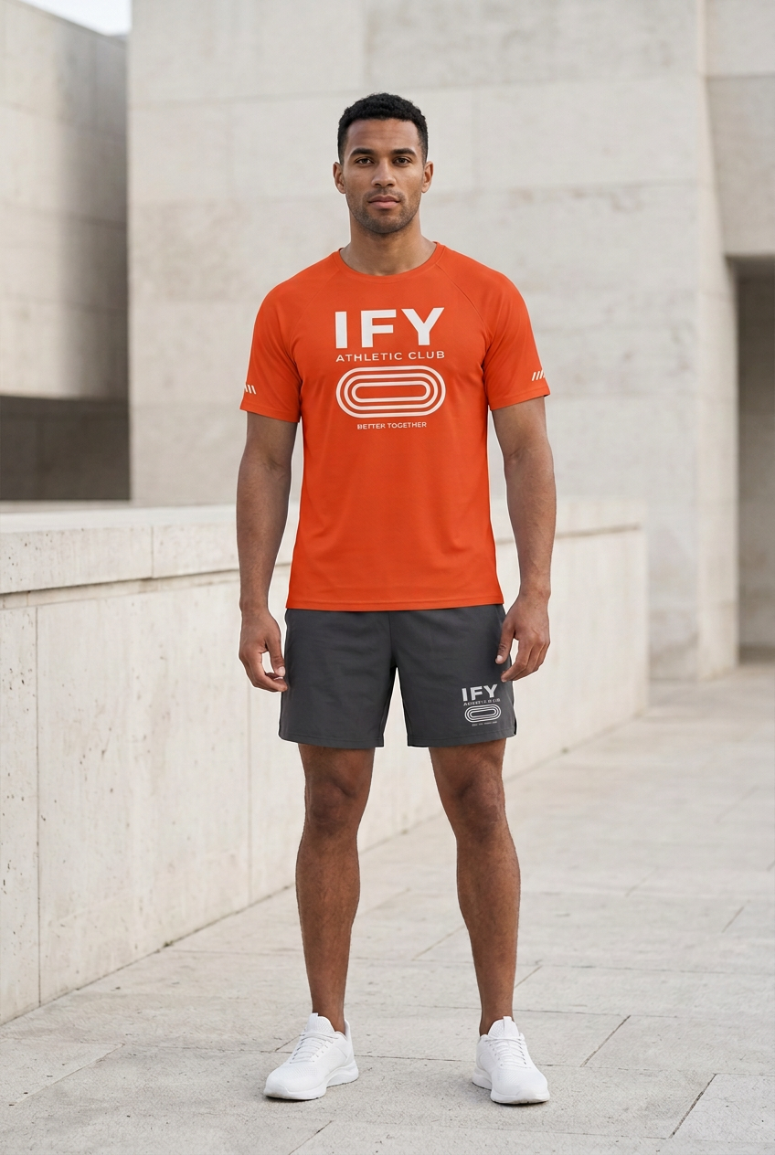 Male model wearing orange IFY Athletic Club performance T-shirt and charcoal shorts with matching white IFY logo.