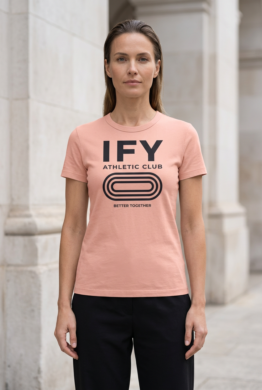 Female model wearing pink IFY unisex heavyweight slim-fit T-shirt with black Athletic Club front graphic