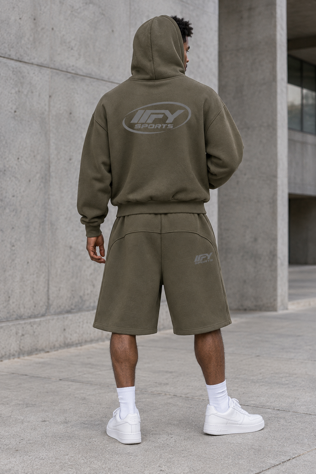 Male model back view wearing the olive IFY hoodie and shorts with Nike trainers