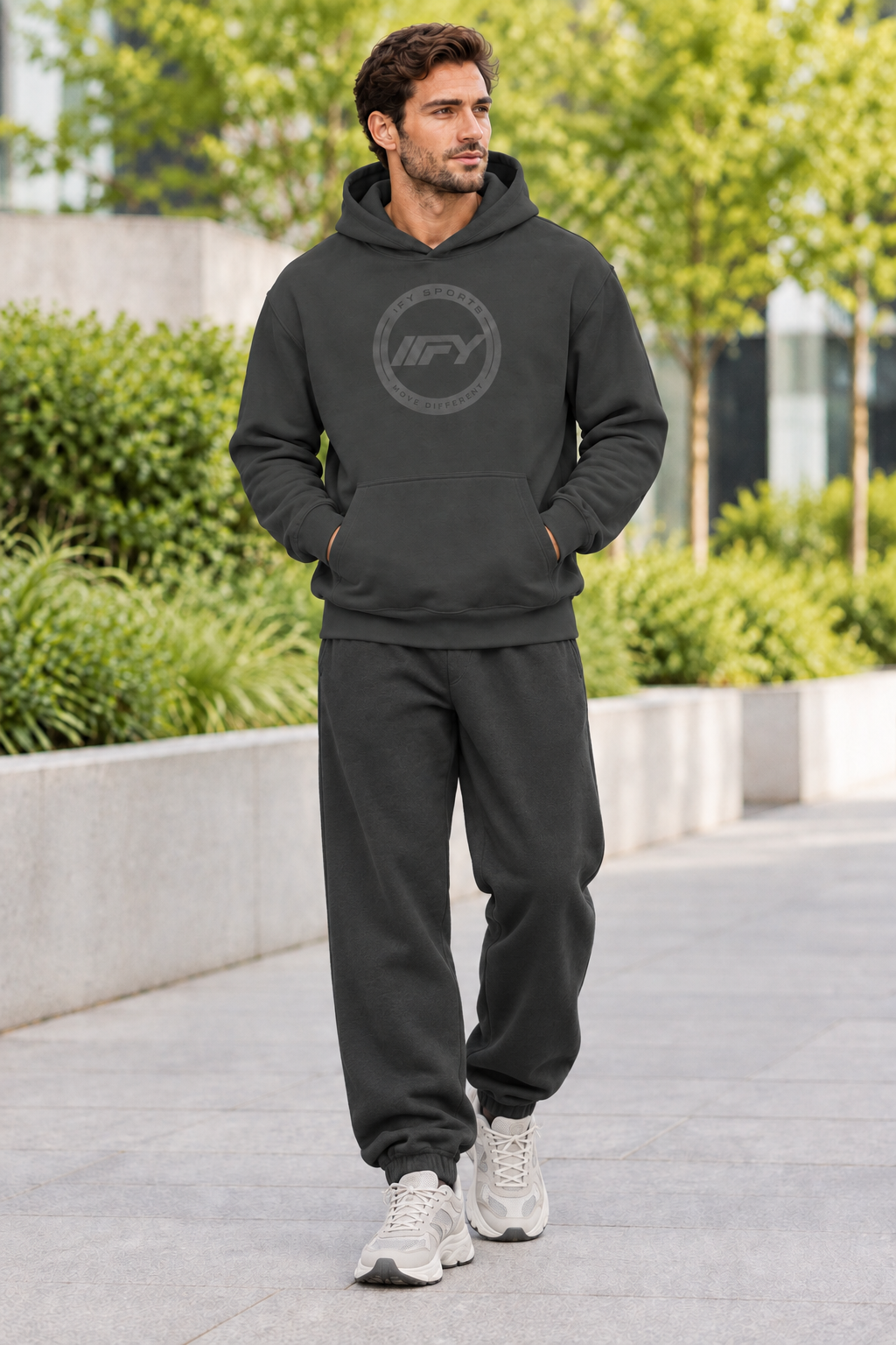 Male model in a charcoal IFY hoodie with relaxed sweatpants and chunky trainers
