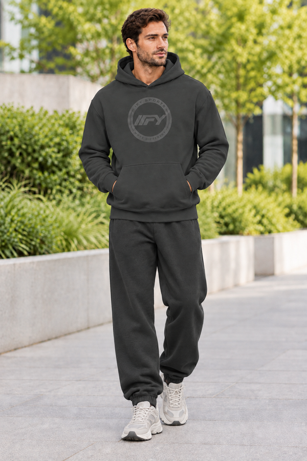 Male model in a charcoal IFY hoodie with relaxed sweatpants and chunky trainers