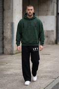 Male model in dark green IFY hoodie and black sweatpants, front view