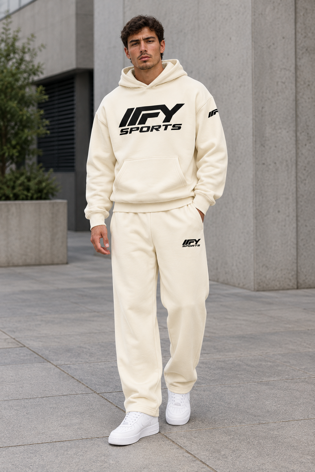 Male model wearing the cream IFY hoodie and sweatpants set with white Nike Air Force 1 trainers