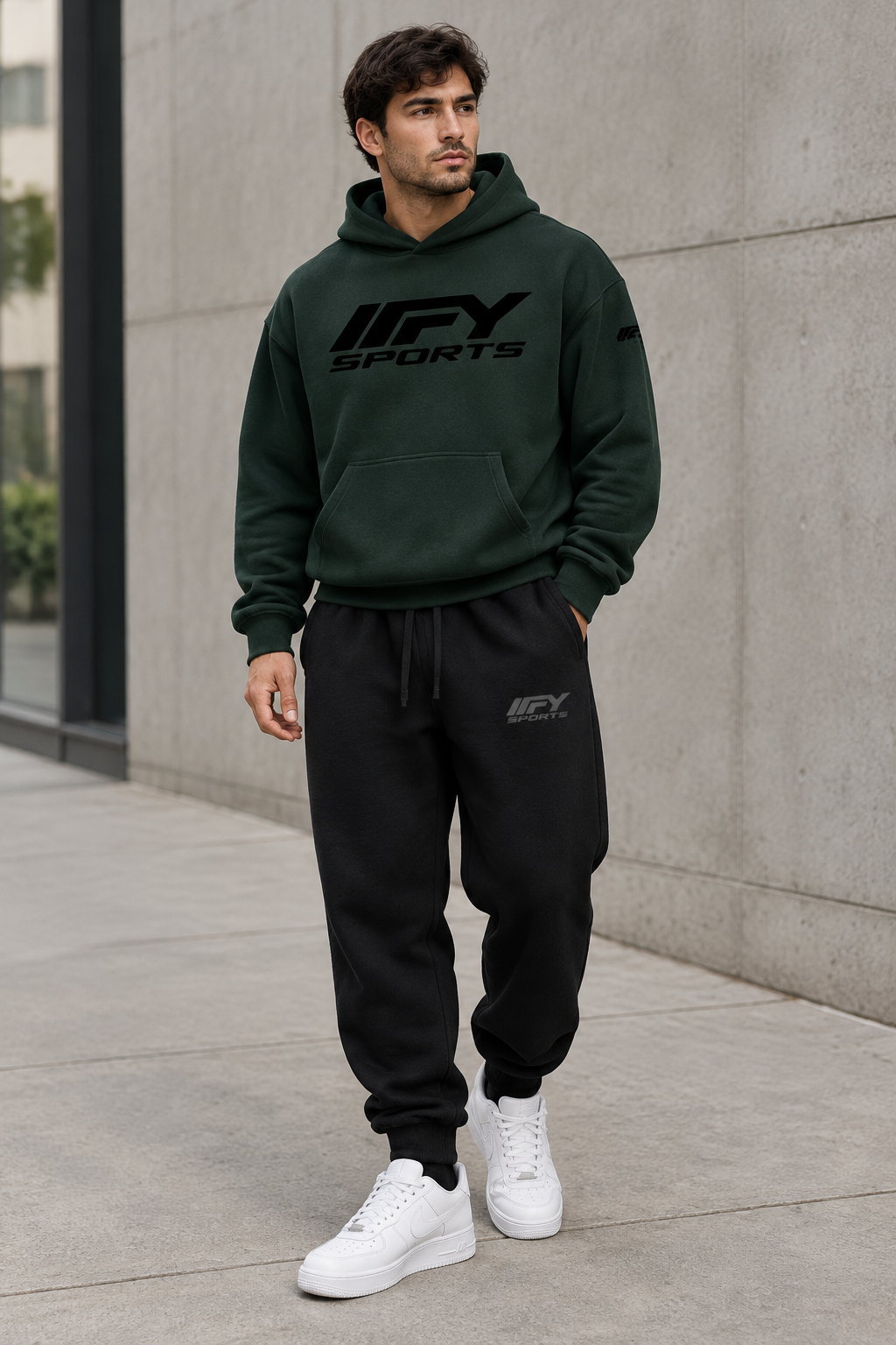 Male model wearing the dark-green IFY hoodie and black cuffed joggers with Nike trainers