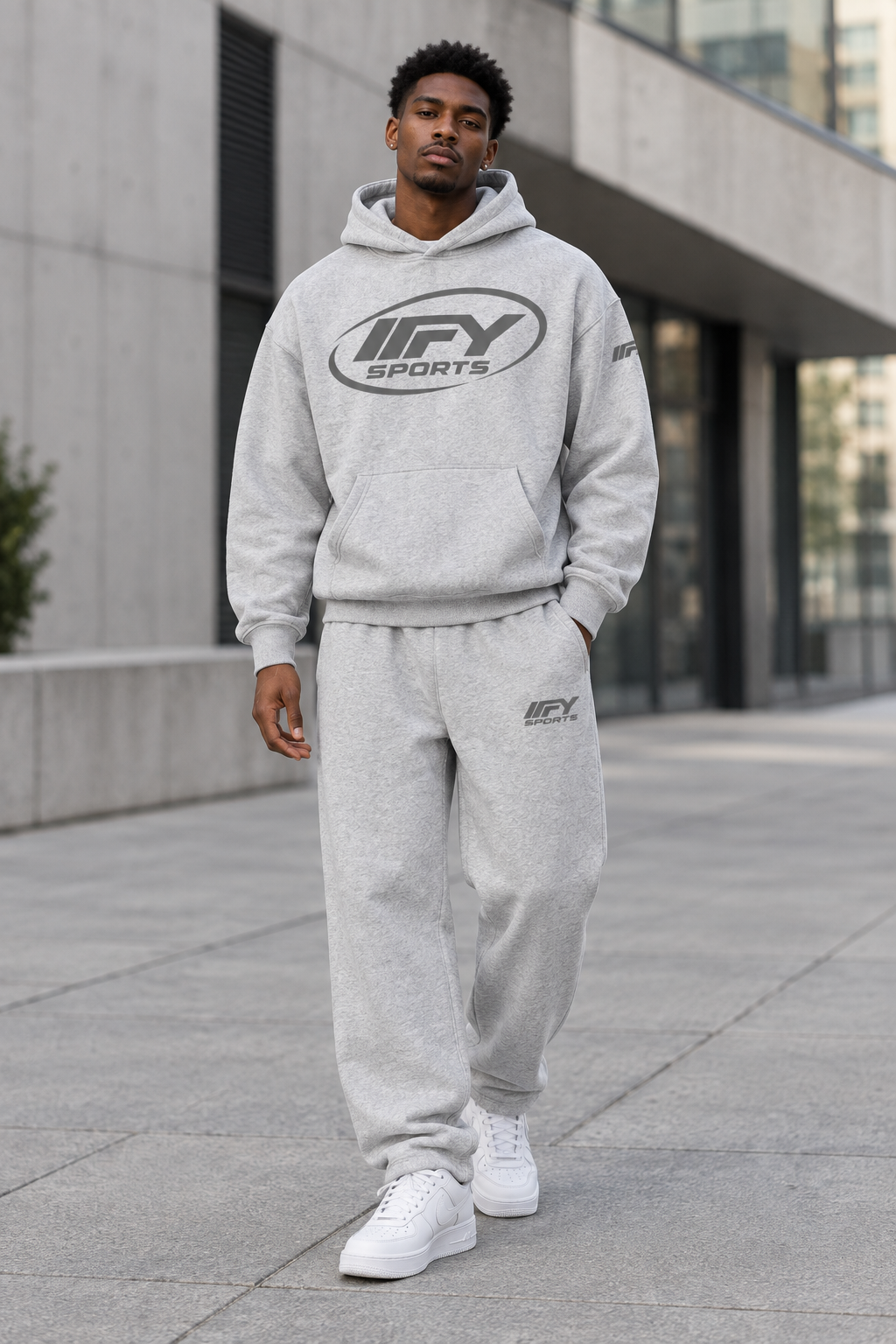 Male model wearing the grey IFY hoodie and sweatpants set with white Nike Air Force 1 trainers