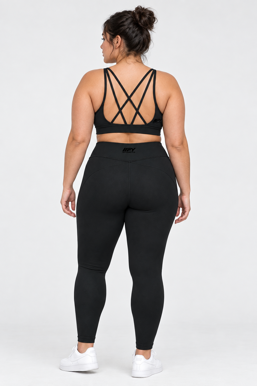 Plus-size female model back view wearing the black IFY cross-strap bra and leggings