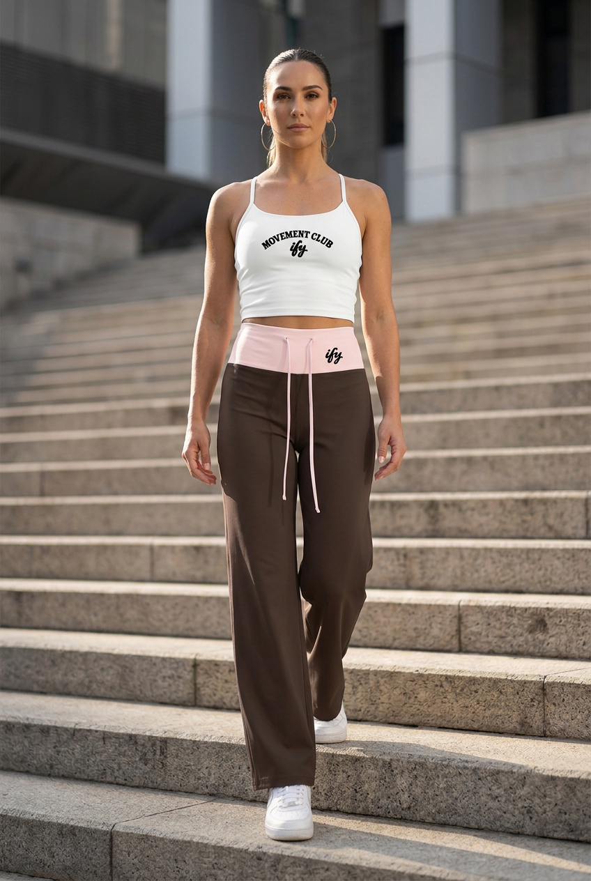 Straight-on front view of white top and brown trousers